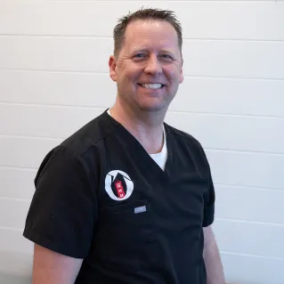 Dr. Brian Call, smiling, in dark scrubs